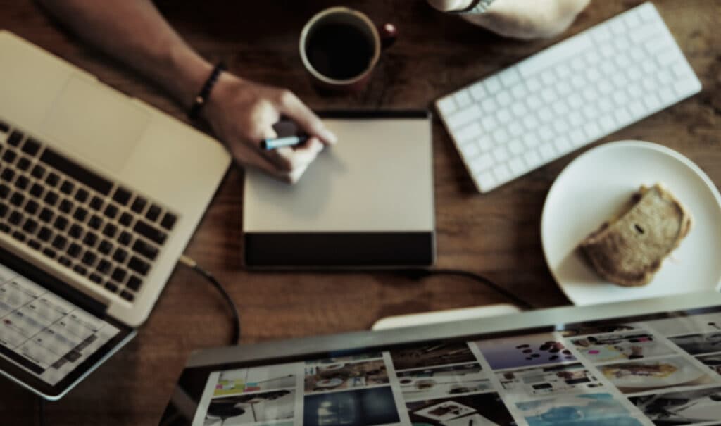 Poste de travail créatif avec MacBook et tablette graphique illustrant la phase de conception dans un projet digital