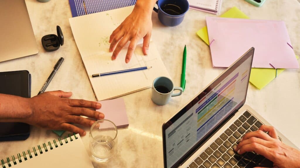 Séance de travail collaboratif avec laptop et post-its illustrant une cérémonie Scrum animée par un Scrum Master