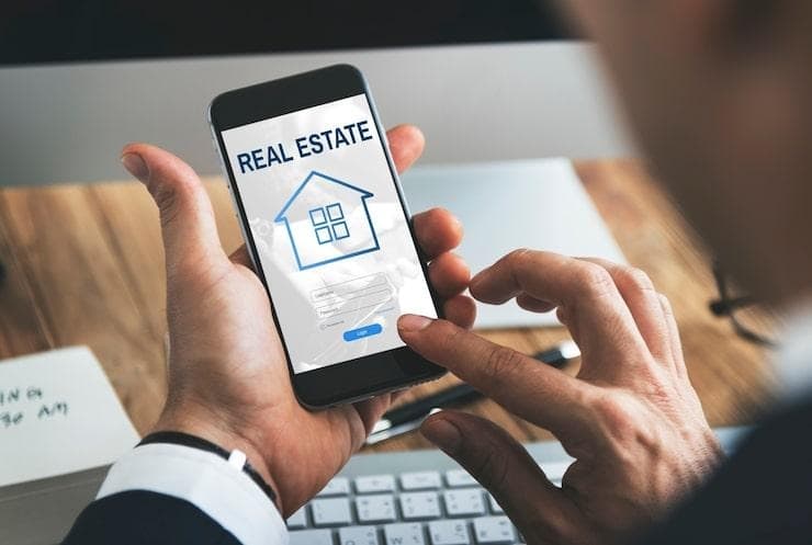 Un homme sur son smartphone qui utilise une app immobilière