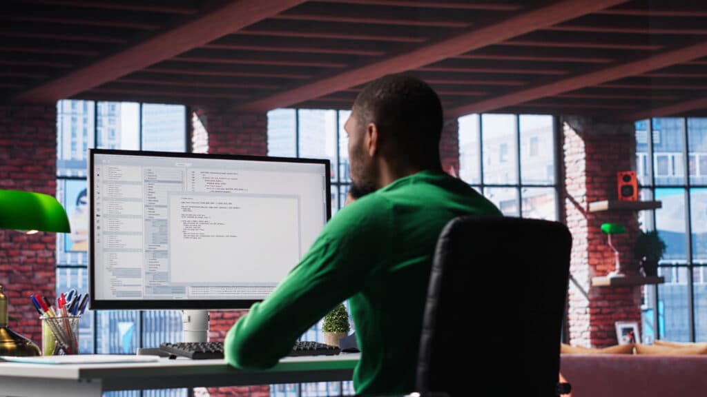 Ingénieur logiciel analysant une architecture complexe sur un écran haute résolution