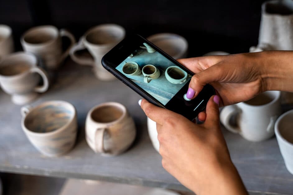 Visiteur utilisant son smartphone pour interagir avec une exposition de peintures